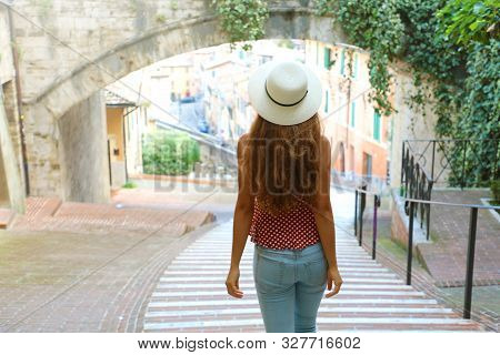 Back View Of Young Woman Walking In Old Medieval Town Of Perugia, Italy.