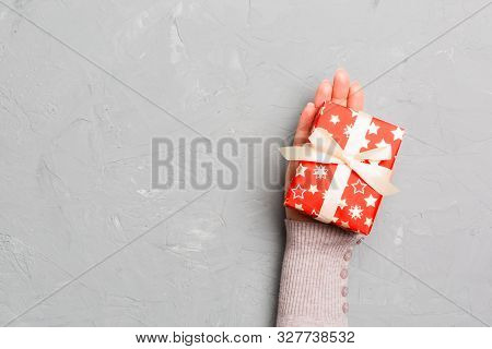 Top View Woman Hands Holding Present Box With Colored Bow On Gray Cement Wooden Background With Copy