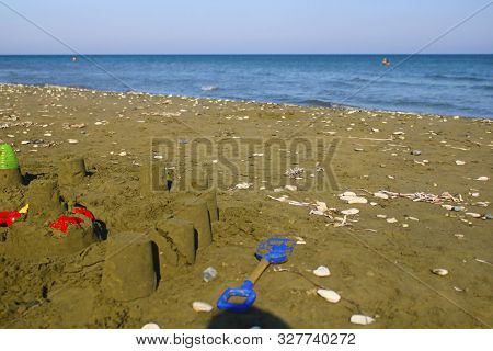 Travel Background With Bright Plastic Toys In The Sand Of A Beautiful Beach, Horizontal With Copy Sp
