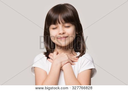 Cute Little Girl With Hands On Chest Praying