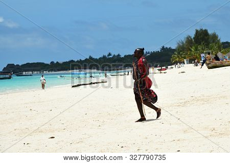 Kendwa, Zanzibar - October 3, 2019: Man From Masai Tribe In Traditional Dress Walks Along Kendwa Bea