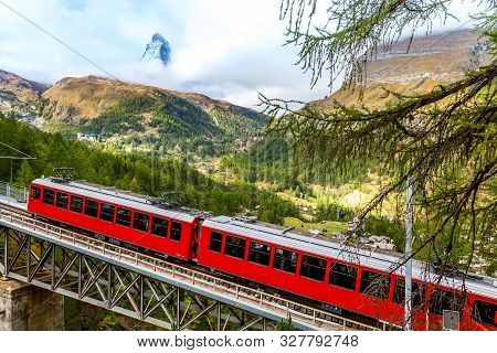 Zermatt, Switzerland. Gornergrat Red Tourist Train On The Bridge And Matterhorn Panorama In Swiss Al