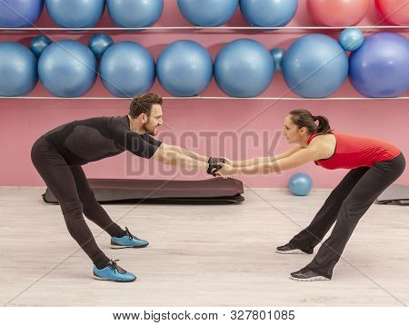 Young Man Helped By His Coach Doing Stretching Exrcises In A Gym.
