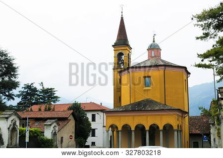 Yellow Italian Church Exterior With Columns In Mandello Del Lario.