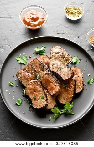 Grilled Sliced Beef Liver On Plate Over Black Stone Background. Cooked Liver(offal) From Beef Meat. 