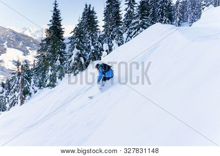 Photo of sporting man riding snowboard on snowy slope