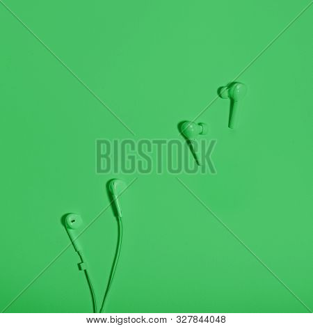 Wireless In Ear Headphones And Cable Earphones On Mint Green Background Close Up. Minimal Music Conc
