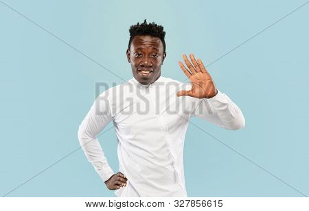 Nice To See You. Young African-american Man Isolated On Blue Studio Background, Facial Expression. B