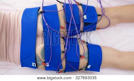The Girl Lies On The Couch And Receives The Procedure Of Myostimulation On Her Legs And Buttocks In 