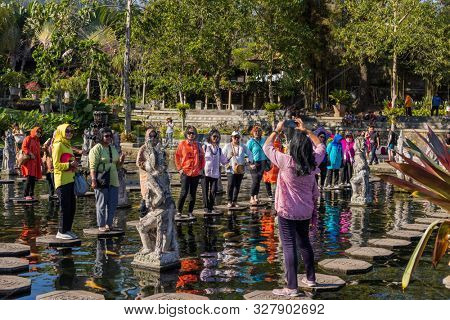 Bali, Indonesia - 17 September 2019: People walking on the stepstones of Tirtagangga Water Palace in Bali, Indonesia