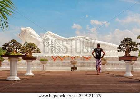 Young Man Travel In Bali, Indonesia. Tourist Walk In Buddhist Temple Vihara Dharma Giri, See At Lyin