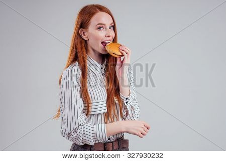Redheared Hungry Woman In Striped Shirt Eating Usa Burger Visa Traveler White Background Studio
