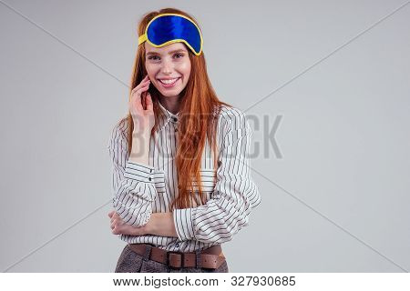 Good Morning. Smiling Redhead Young Business Woman In A Striped Shirt And Blue Yellow Sleep Mask Whi