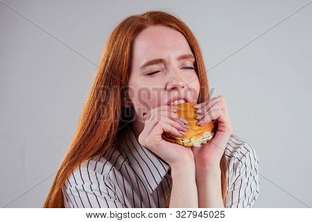 Redheared Hungry Woman In Striped Shirt Eating Usa Burger Visa Traveler White Background Studio