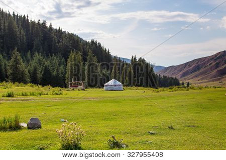 Summer Landscape In The Mountains. Tall Trees Of A Christmas Tree, The National Dwelling Is A Yurt. 