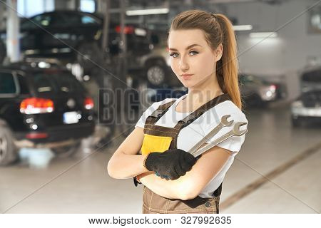 Charming, Beautiful Girl Holding Wrenches, Looking At Camera, Posing. Pretty Young Woman Working As 