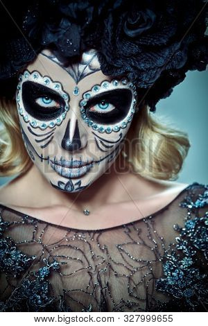 Close-up portrait of Calavera Catrina. Young woman with sugar skull makeup. Dia de los muertos. Day of The Dead. Halloween.