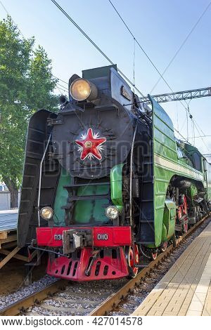 Green Retro Steam Locomotive At The Railway Station On A Sunny Day