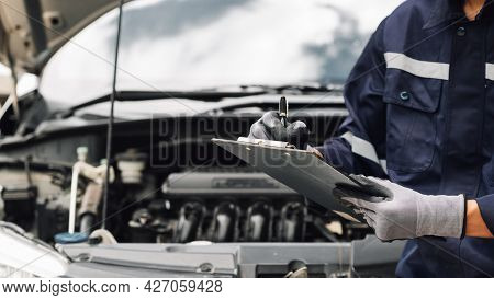 Car Service, Repair, Maintenance Concept,auto Mechanic Man Or Smith Writing To The Clipboard At Work