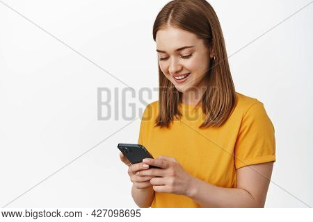 Portrait Of Young Woman Look At Smartphone Screen And Smiling, Reading Message On Cell Phone, Using 