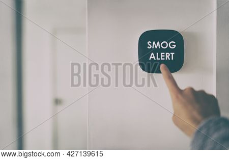 Smog warning on smart home air quality touchscreen indoor AQI screen alert. Woman touching domotic device inside house.