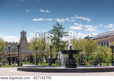 Russia, Irkutsk - May 27, 2021: Fountain And Hotel Angara In Tikhvinsky Or Kirov Square In Sunny Sum