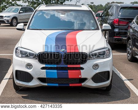 Monroeville, Pennsylvania, Usa July 18, 2021 A White Bmw Suv With Multi Colored Stripes On The Hood 
