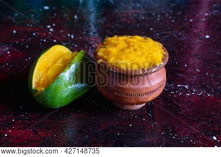 Ripe Mango Pulp In Earthen Bowl With Mango Isolated On Dark Background