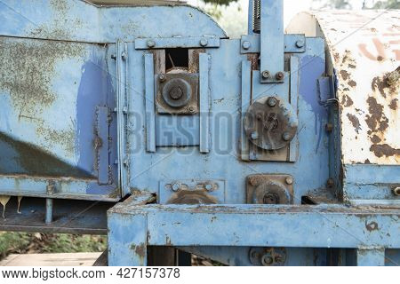 Old Rusted Machinery Painted In Blue Color Kept Under Sunglight.