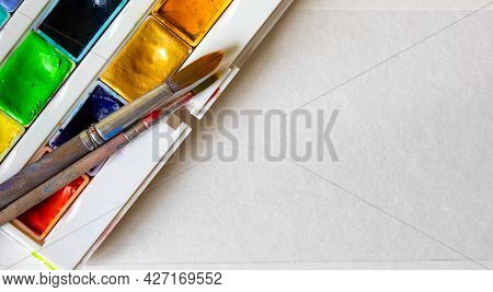 Watercolors In Cuvettes In A Box And Brushes For Painting On A Sheet Of Paper.