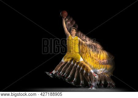 Power And Speed. One Young Basketball Player Training With Ball Isolated On Dark Background With Str