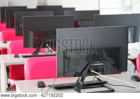 A Variety Of Computer Monitors Or Monoblocks - Panel Pc Installed On Tables In A Library, Classroom 