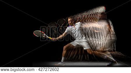 Portrait Of Young Man, Male Tennis Player In Motion And Action Isolated On Dark Background. Strobosc
