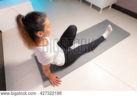 Sporty Slim Caucasian Woman Doing Self Massage On Fitness Mat With Massage Ball Indoors. Self-isolat