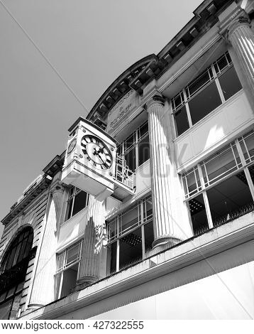 SOUTHEND ON SEA, UK - 19th July 2021: Historic 1890s store front and clock in Southend High Street, taken in black and white. 