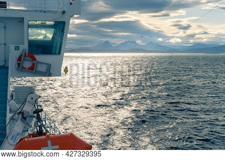 Cabin Of A Boat Sailing In The Sea By Lofoten Islands. Dramatic Clouds And Mountain Range On The Dis