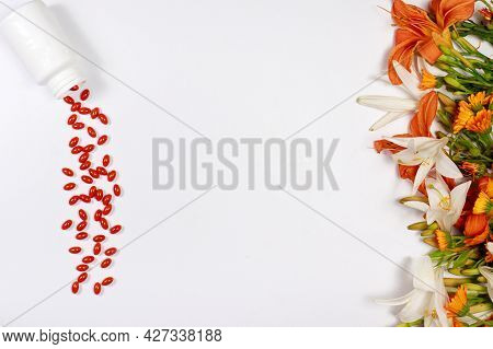 Orange Capsules Of Lutein And Medicinal Plants On A White Background With Place For Text. Supplement