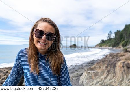 Brunette Woman With Long Hair Smiles And Poses At Kalaloch Beach In Olympic National Park