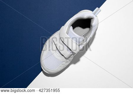 Top View Macro On One White Childrens Running Shoe With Velcro Fasteners For Quick Shoeing On A Tren