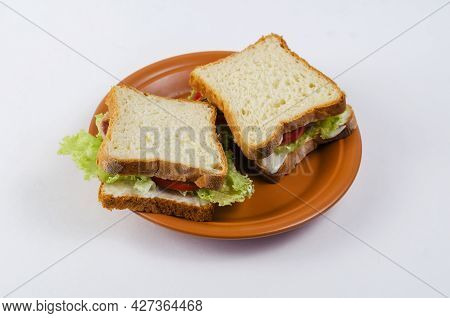 Tuna Sandwiches In A Brown Plate On A White Background. Two Brown Sandwiches With Fish, Red Tomatoes