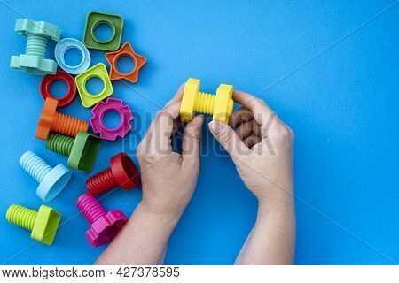 Hands Collect Educational Constructor For Children, Nuts And Bolts In The Form Of Geometric Shapes