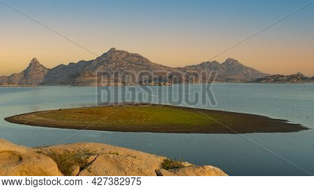 An Island In Jawai Dam With Water Around And Orange Glow In The Sky At Jawai In Rajasthan India