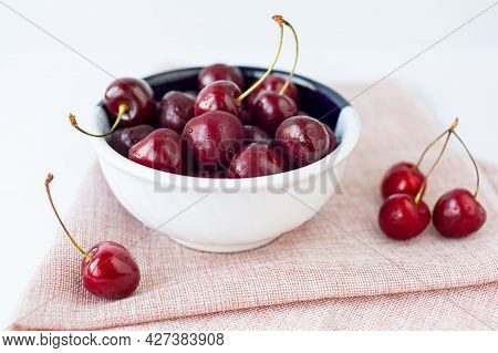 Bowl Of Cherries On Pink Linen Napkin. Sweet, Ripe Berries With Water Drops. Summer Harvest. Close U