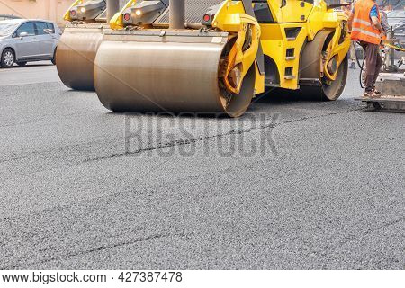 The Metal Cylinders Of The Yellow Road Vibrating Roller Compact The Fresh Asphalt Powerfully On The 