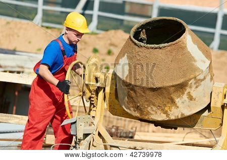 Konstruktor robotnik mężczyzna pracujący z przodu Beton cement mixer w budowie