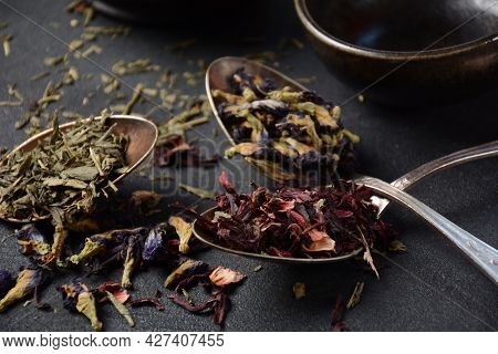 Various Kinds Of Dry Tea Bancha Green, Hibiscus, Butterfly Pea Flower Tea In Spoons On The Table