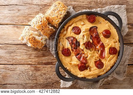 Spanish Food Gachas Of Pea Flour With Paprika Served With Bacon And Chorizo Close-up In A Pan On The