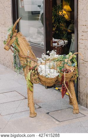 Straw Toy Of An Animal Called Llama With Hanging Saddlebags Filled With Vegetables And Flowers As An
