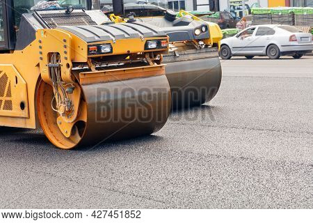 The Metal Cylinders Of Yellow Road Vibratory Rollers Powerfully Compact The Fresh Asphalt On A Road 