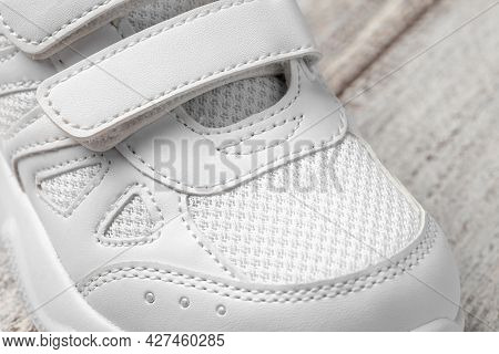 Macro Photo Of The Sneaker. Photo Of A White Childrens Sneaker Made Of Leather And Fabric With A Vel